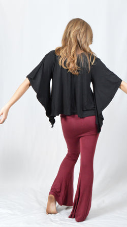 Girl wearing Umba's black Butterfly Sleeve Top with maroon fold over pants, back view, festival fun, sold at Umba Love in Boulder, CO
